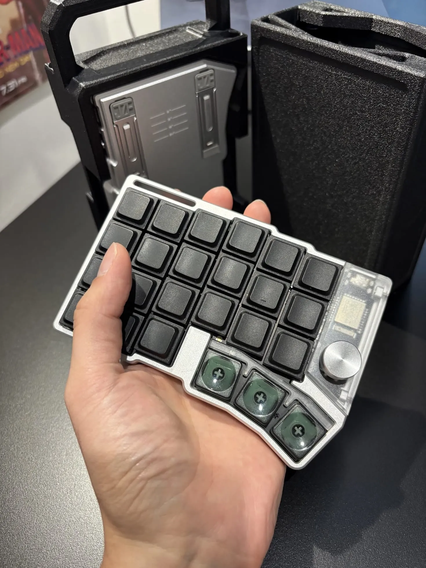 片手に載せたCornix LPの左側と、背後に置いた専用ケース